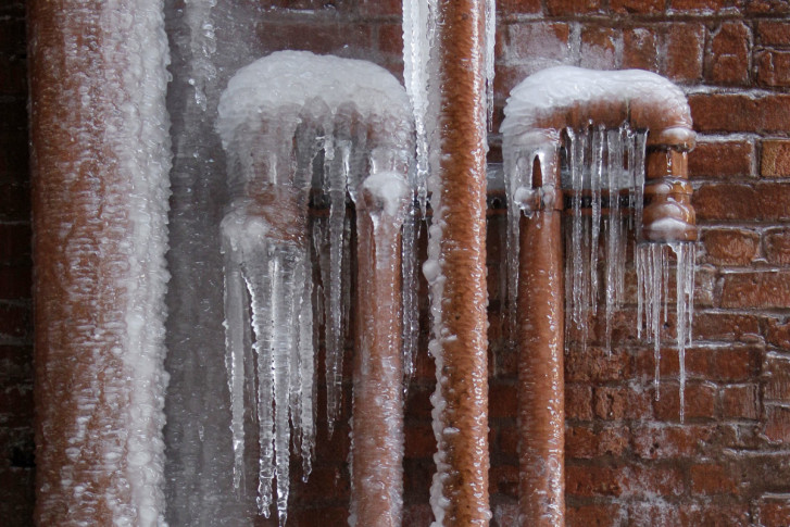 Two outdoor pipes with icicles formed on them